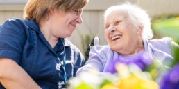 A resident and carer in the garden at Deen Care Residence in Lincoln